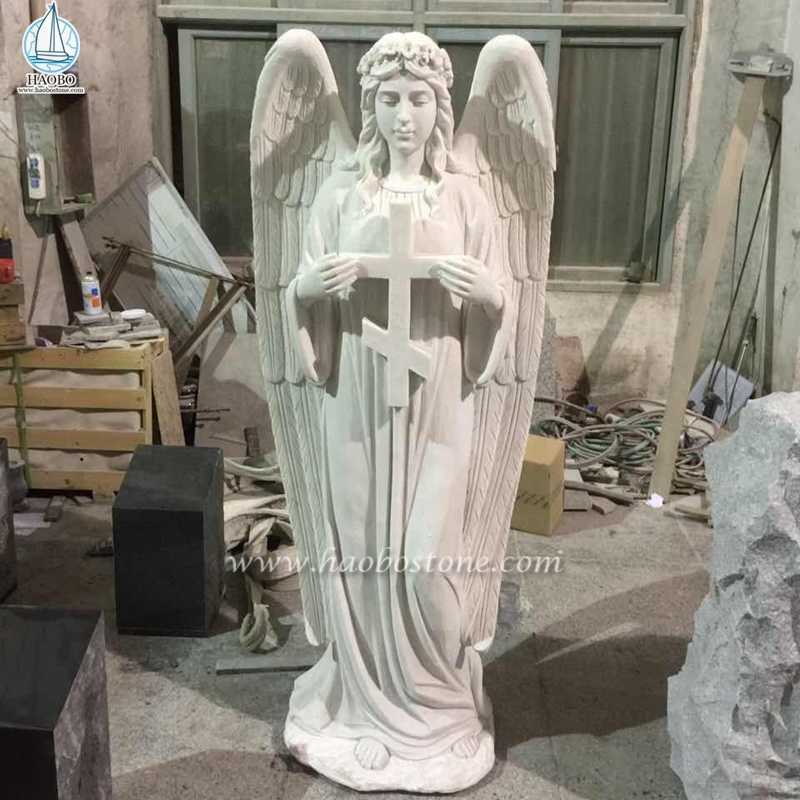 Cruz de mármol blanco con escultura de ángel de pie
